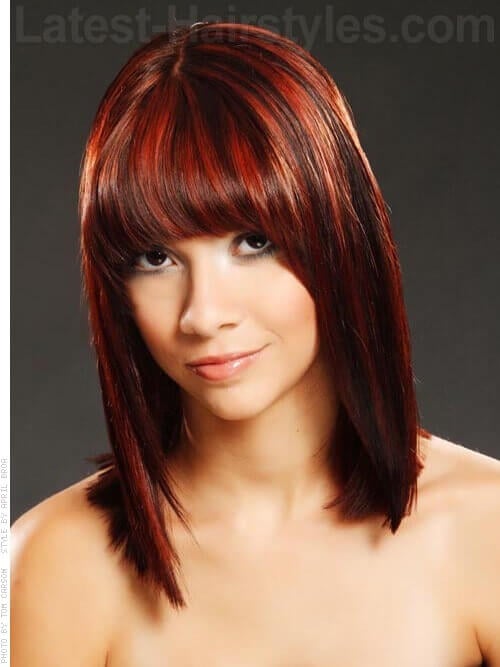 A red sleek shoulder length hairstyle with blunt bangs