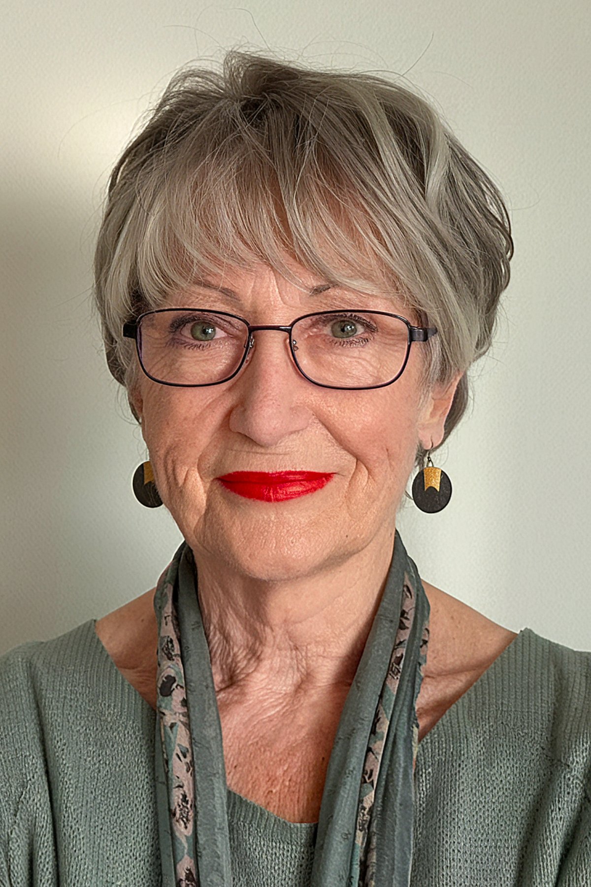 Soft silver pixie haircut with feathered bangs for older women