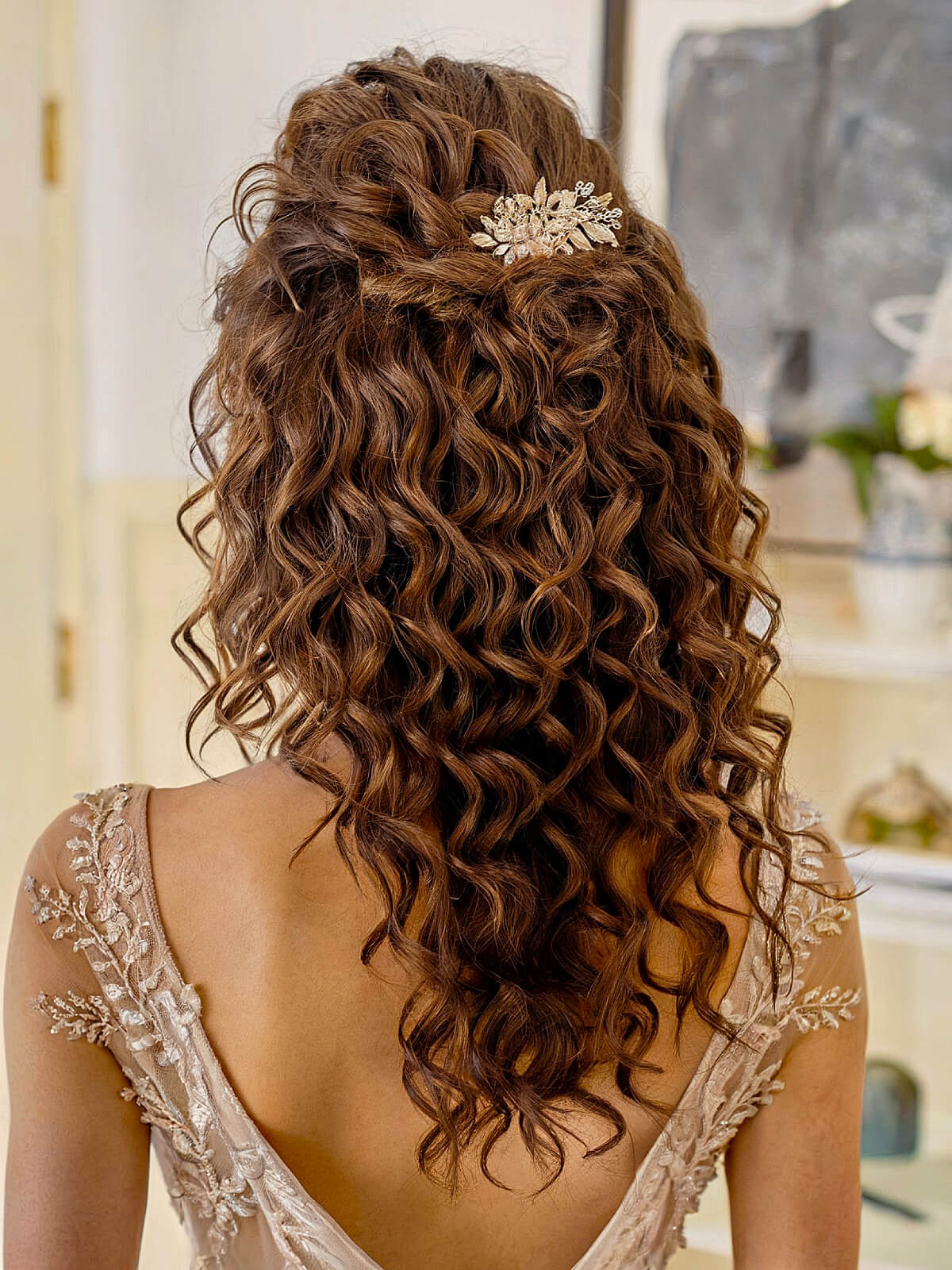 Half-up bridesmaid hairstyle with long curls and floral clip