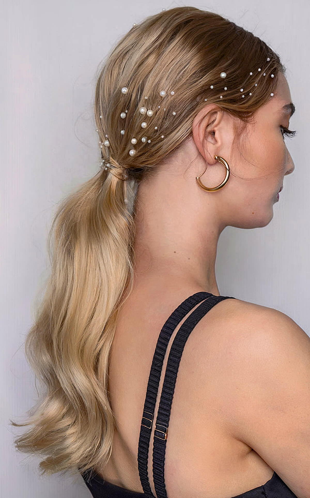 Low wrapped ponytail with pearls for a Christmas party