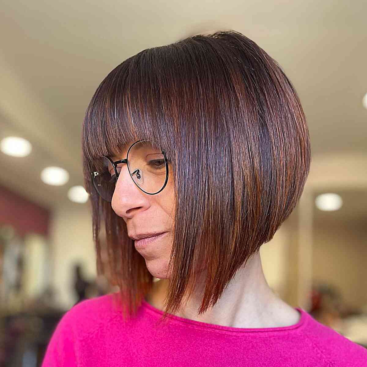 A-line bob with bangs and chocolate balayage for ladies with glasses