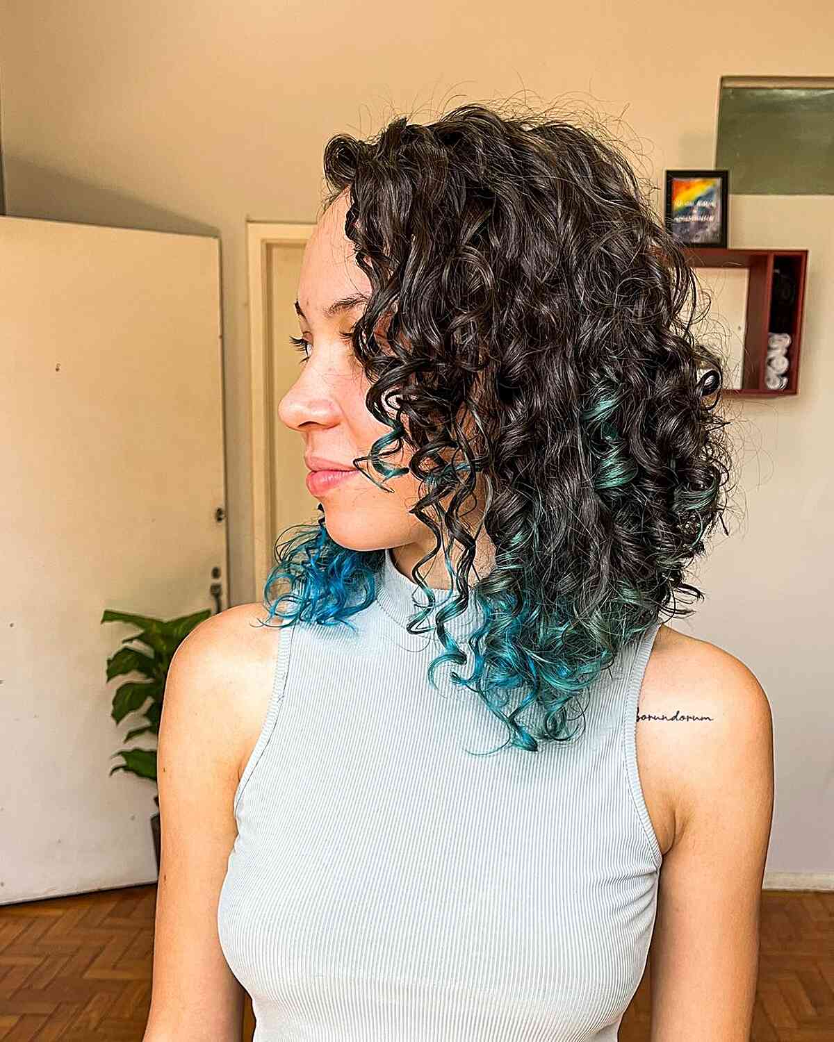 A-Line Curly Graduated Lob with Teal Highlights