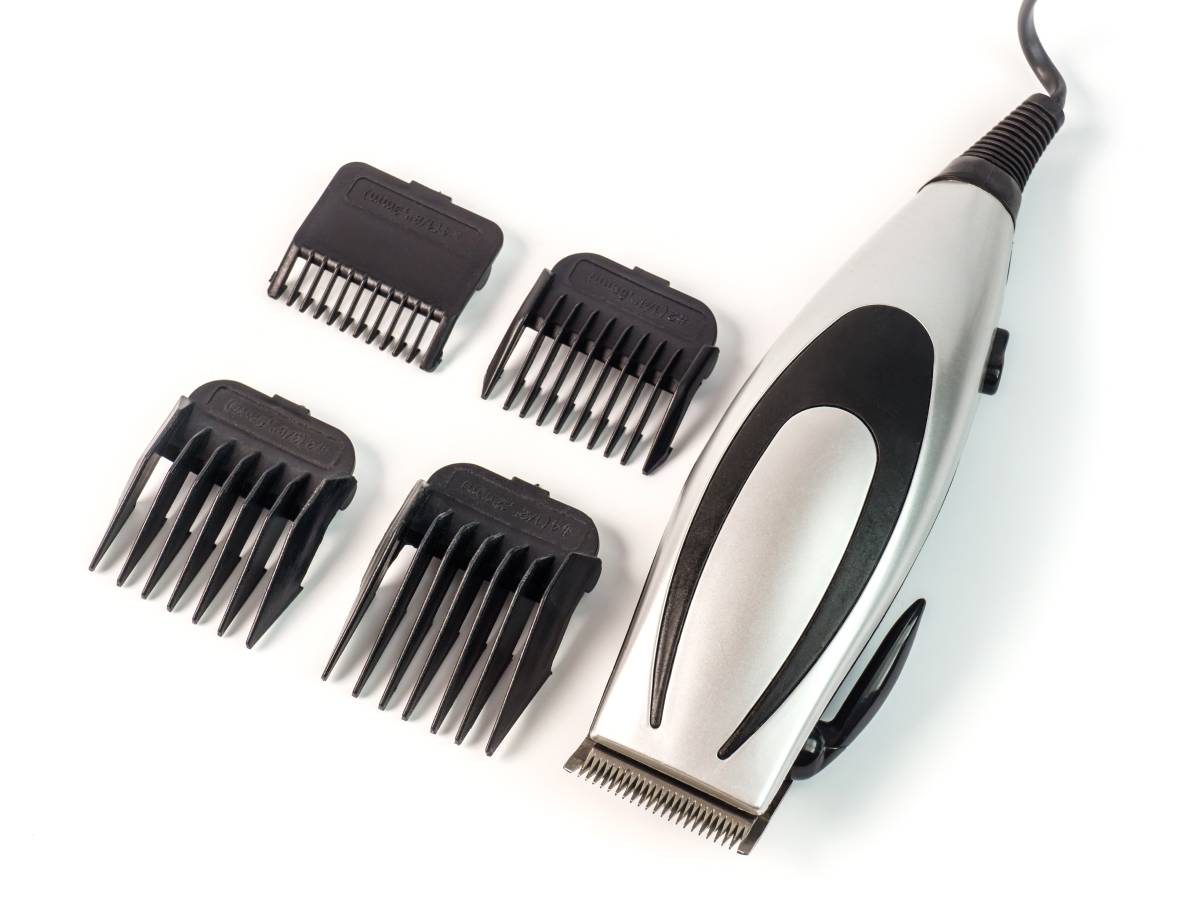 A pair of clippers and several clipper guards surrounding it