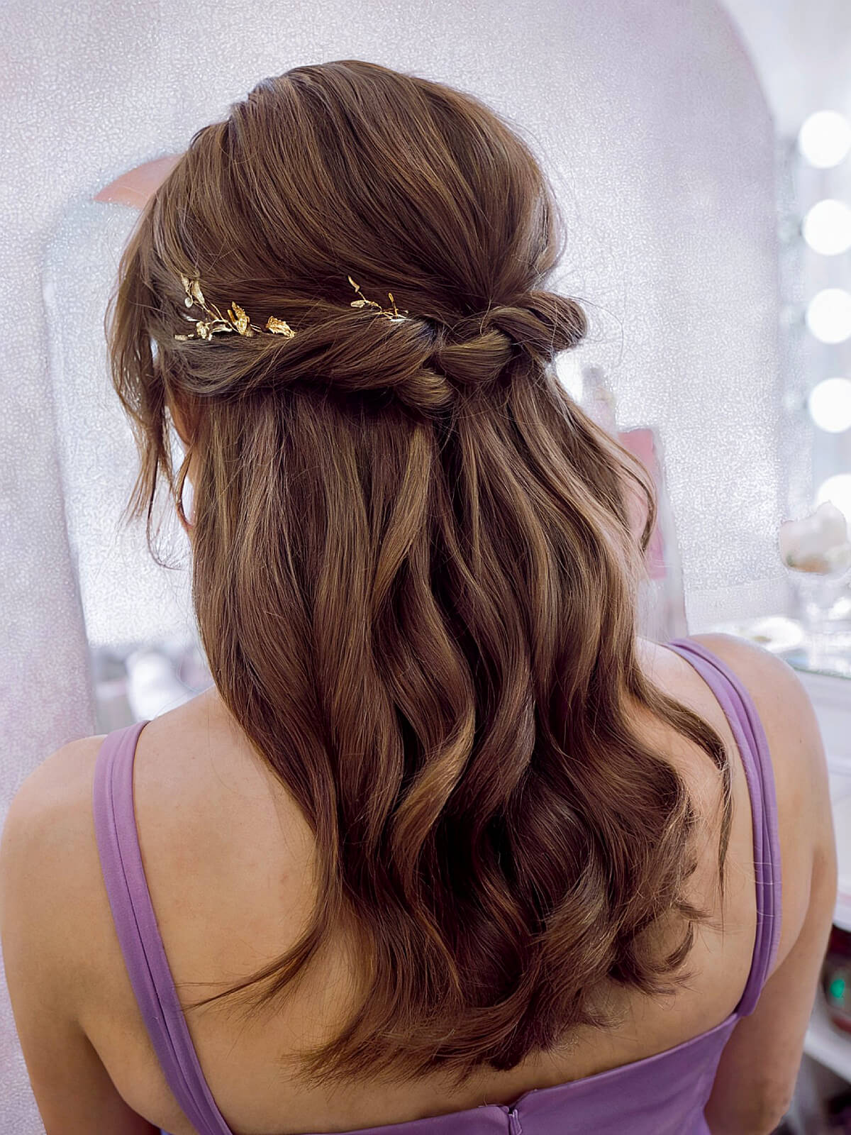 Dark half-up wedding hair with a golden hairpiece