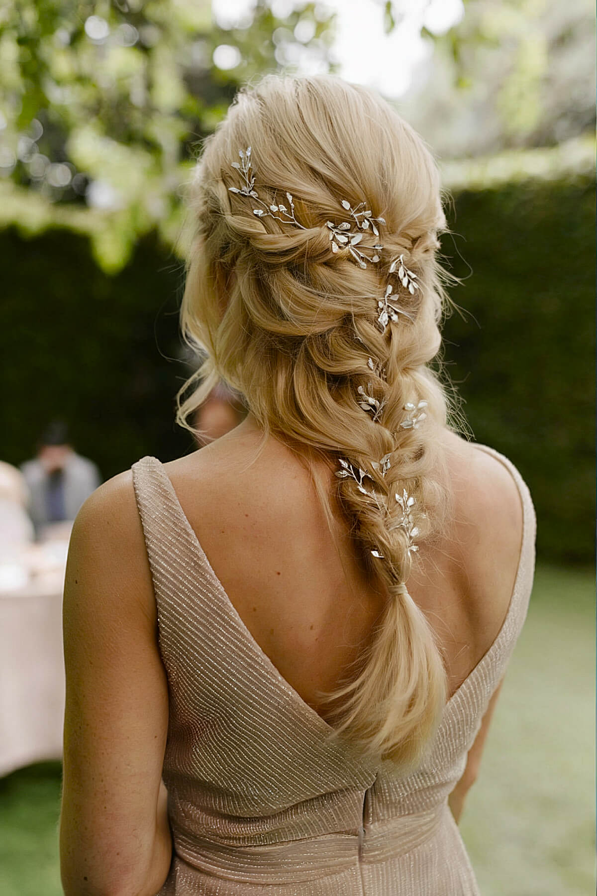 Loose single braid wedding hairstyle with crystal embellishments