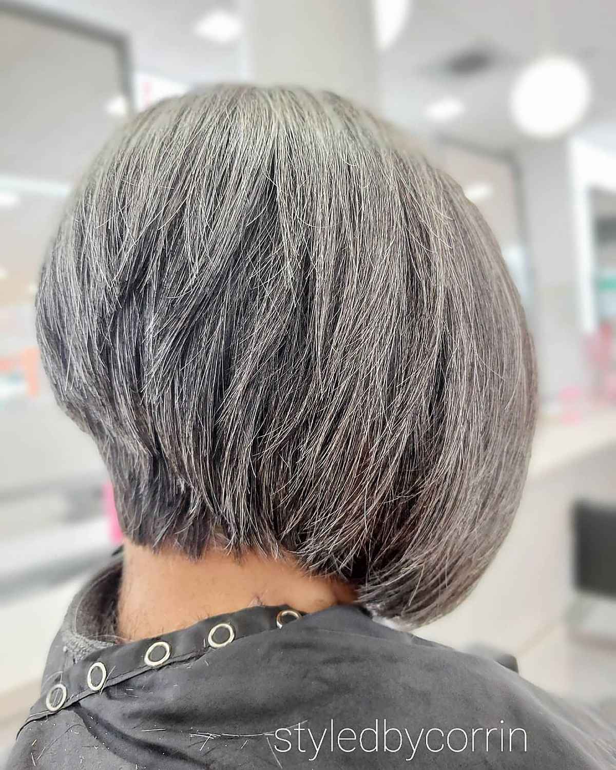A woman over 60 with salt and pepper hair and a wedge cut