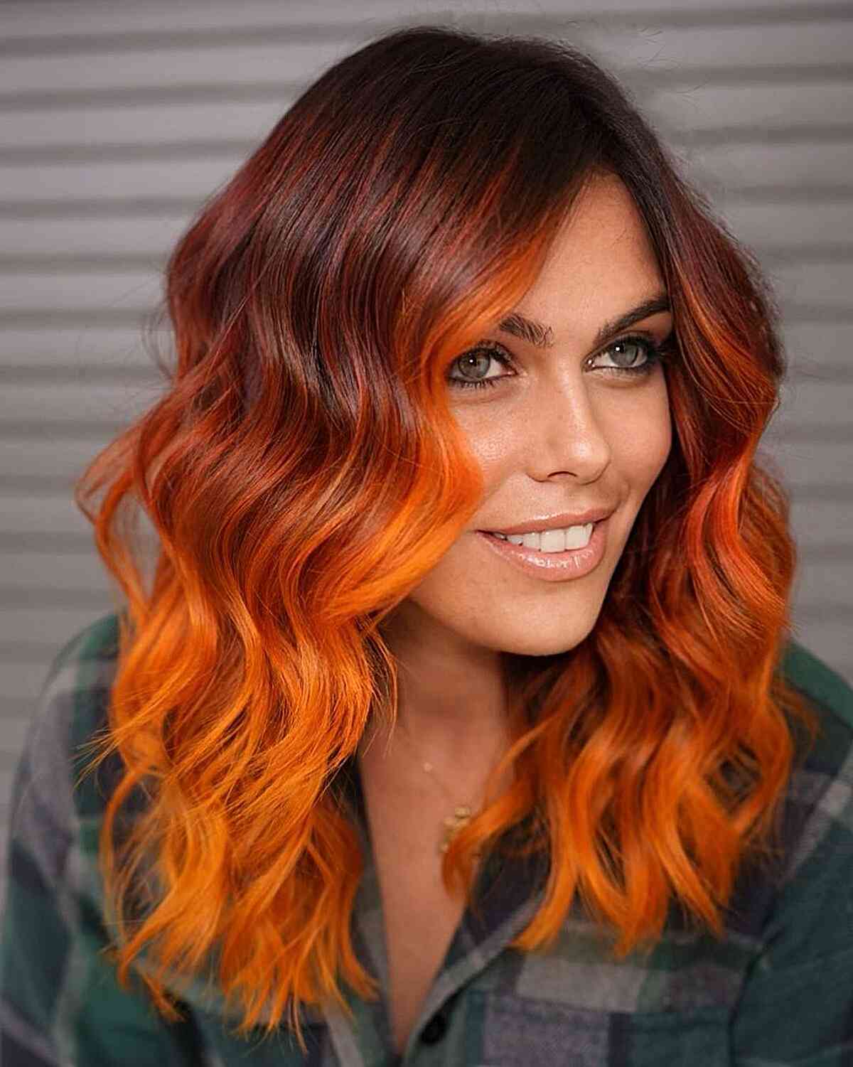 Amped-Up Red to Orange Ombre on ladies with mid-length wavy hair