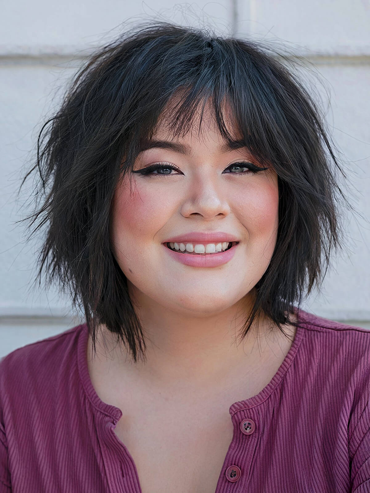 Shaggy bob haircut with choppy layers and curtain bangs for plus size women