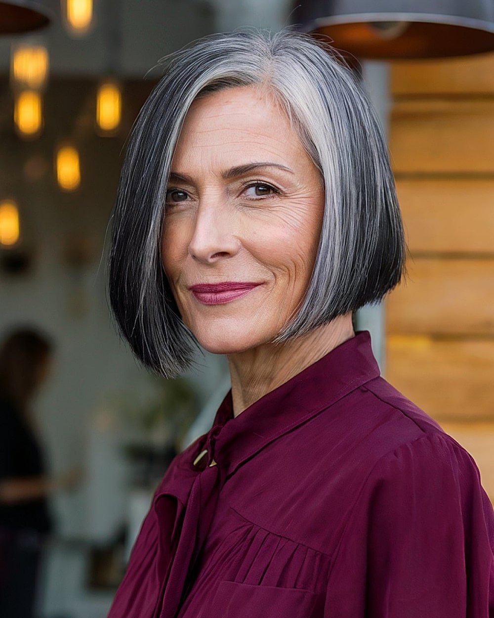 Angled bob haircut with side part and natural gray blending for women over 60