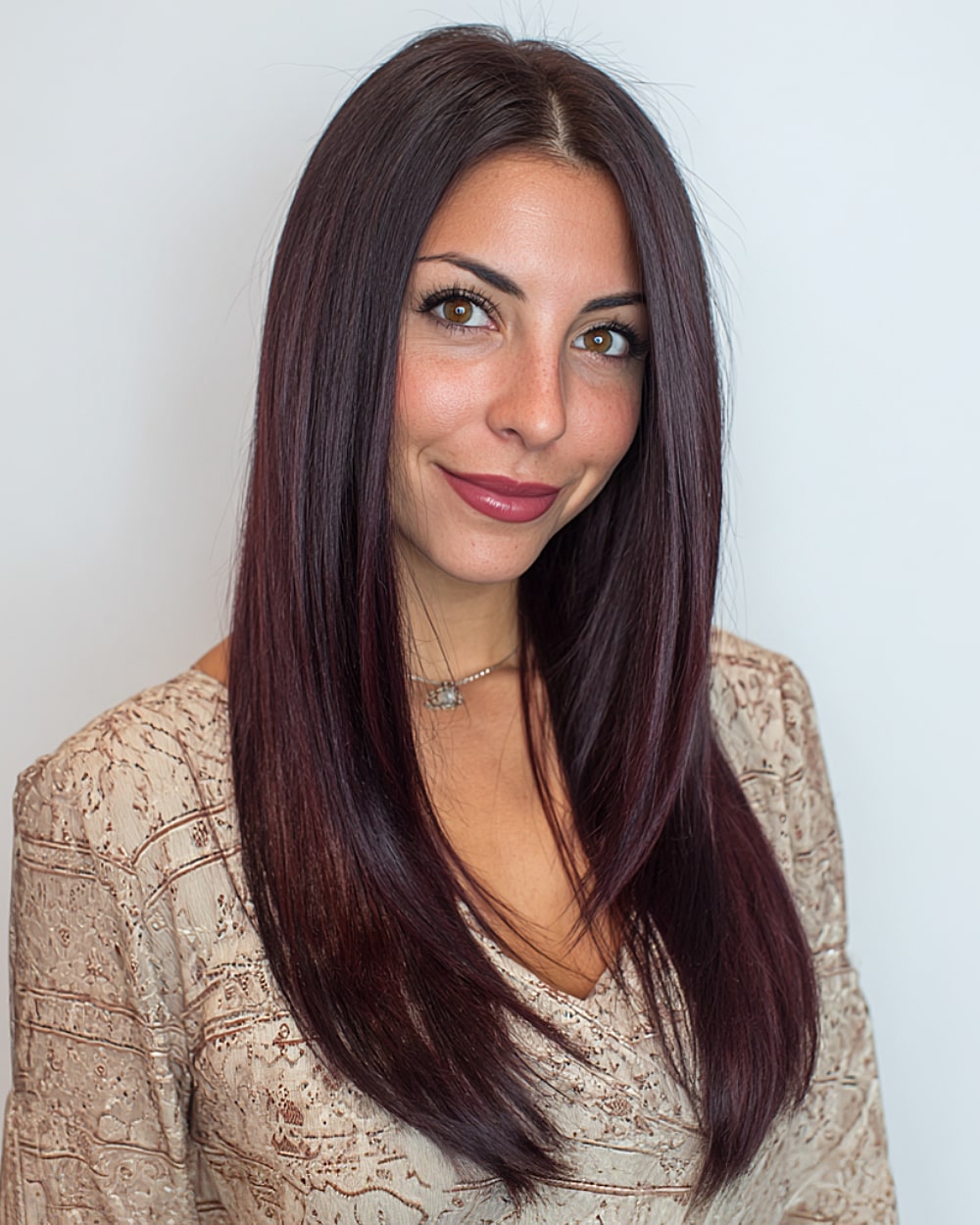 Straight long hairstyle with angled layers and deep burgundy color on thick hair
