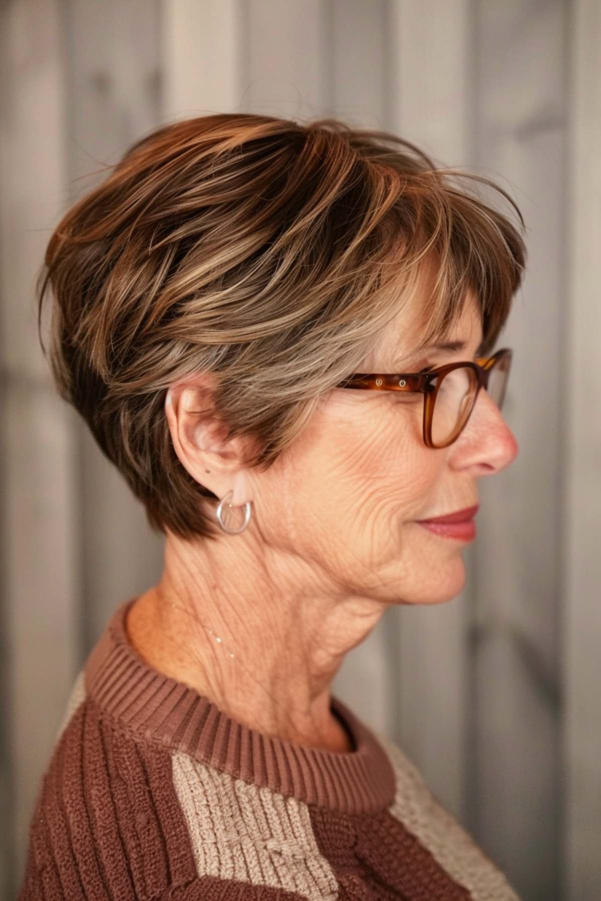 Angular pixie cut with sharp lines and glasses for a modern silhouette.
