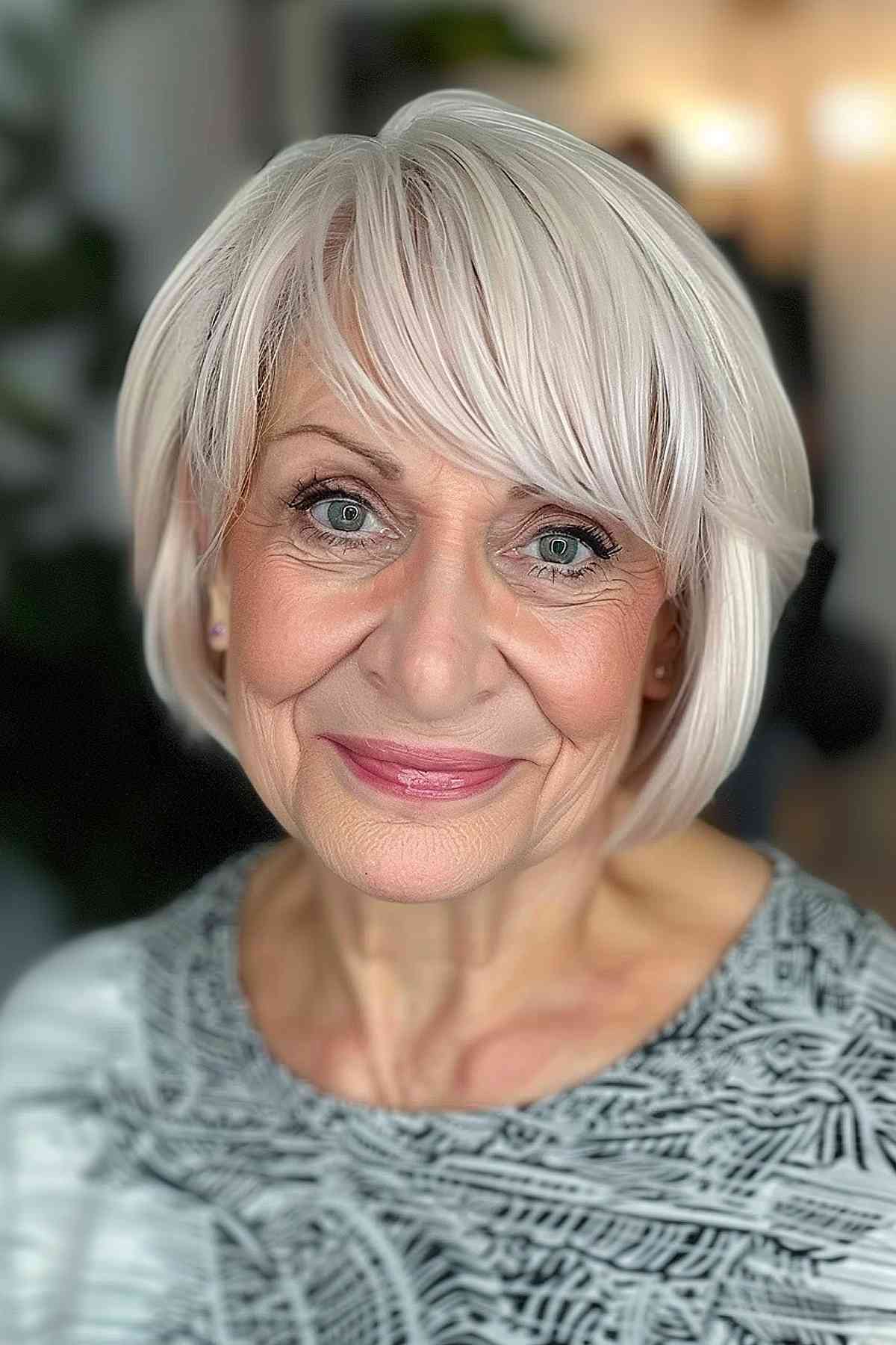 Senior woman with a platinum blonde bob and asymmetric fringe, radiating elegance and youthfulness.