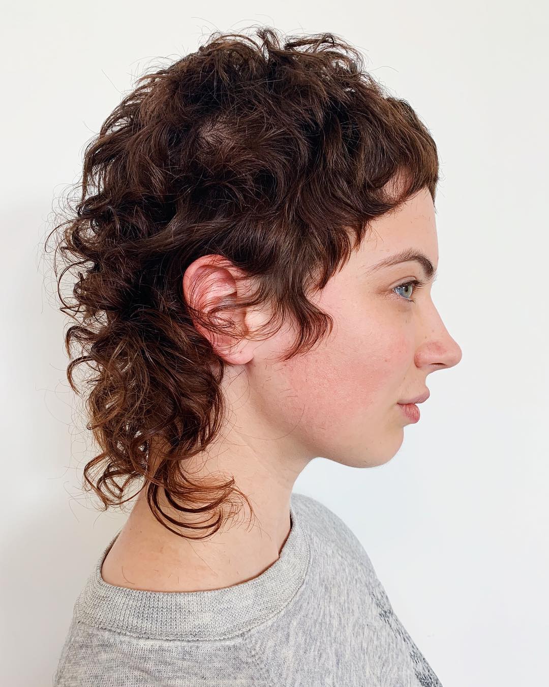 Androgynous Mullet with Short Bangs on Curly Hair