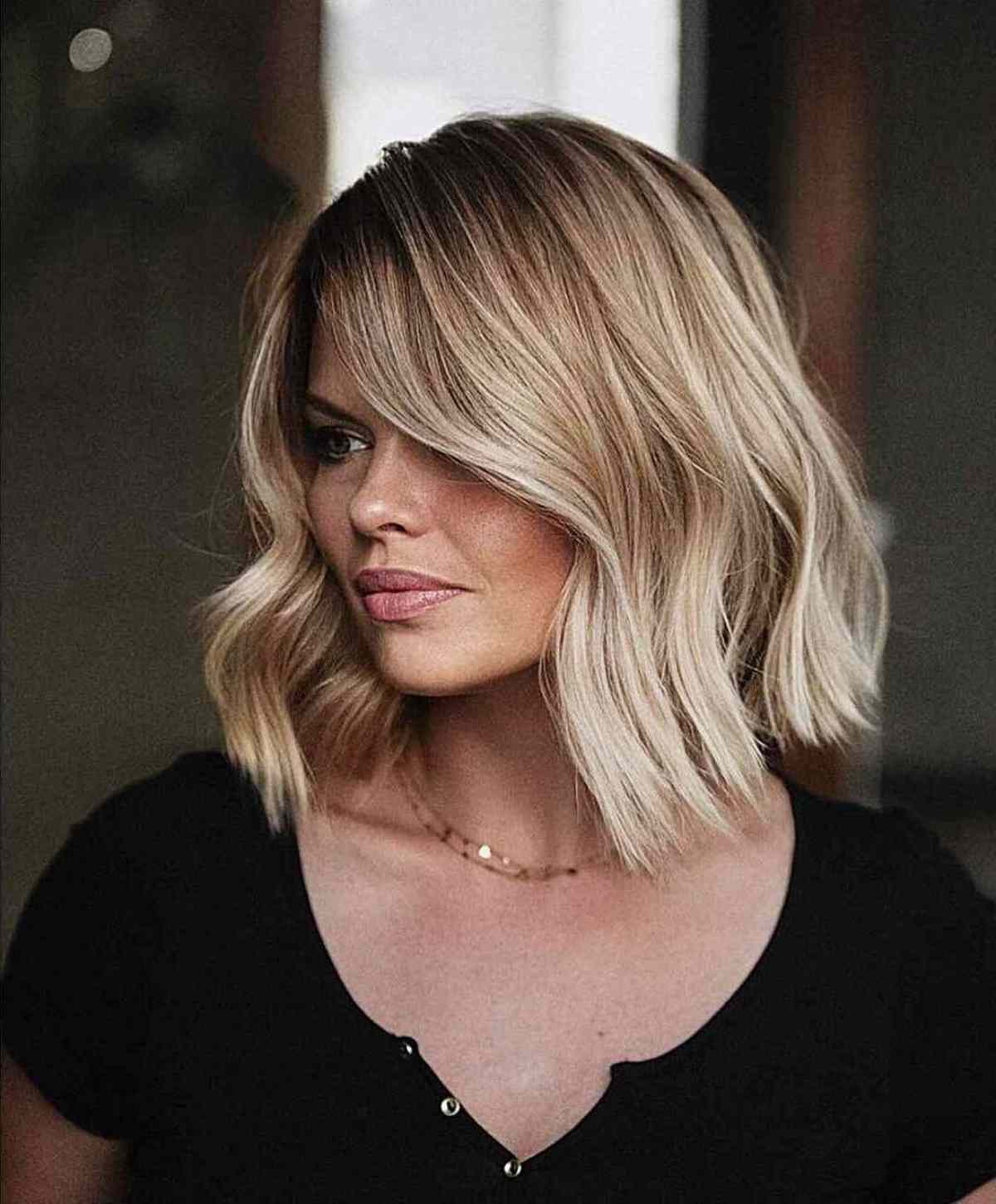 Balayage Blonde Bob with Darker Roots and a Slight Bend in the Hair