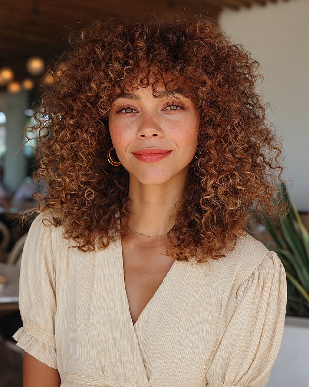 Big bouncy curls with a center part and voluminous curly fringe