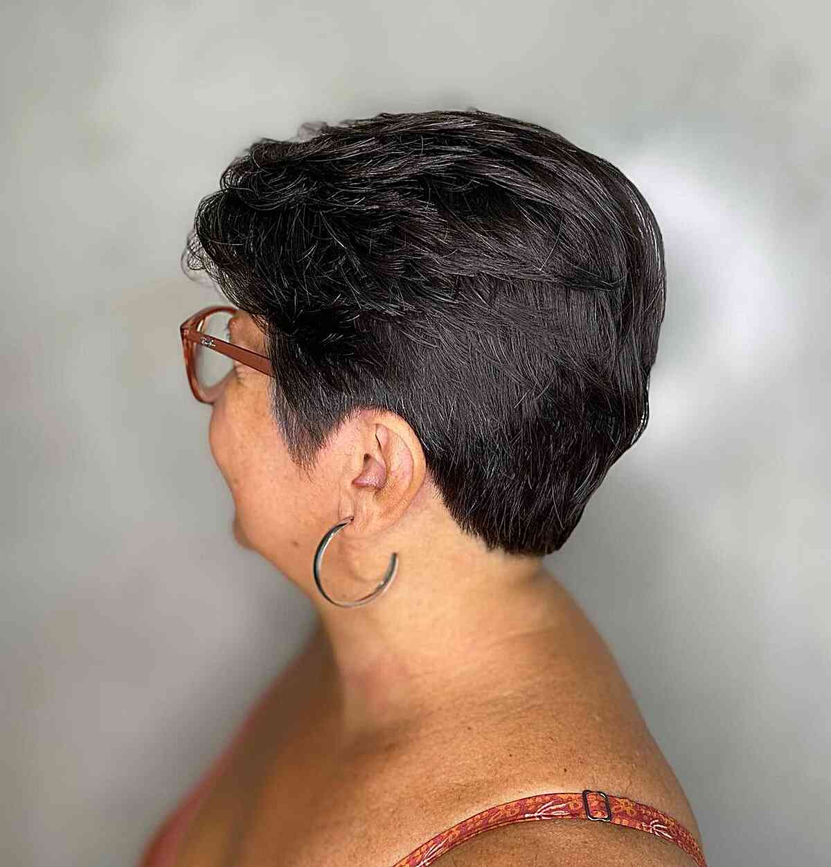 Black Feathered Pixie Haircut for Ladies turning 60 wearing glasses
