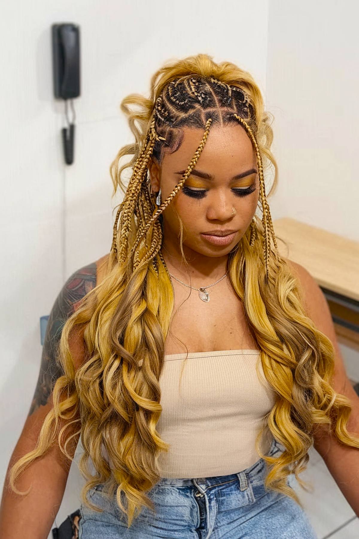 Blonde box braids with French curls in a half-up ponytail