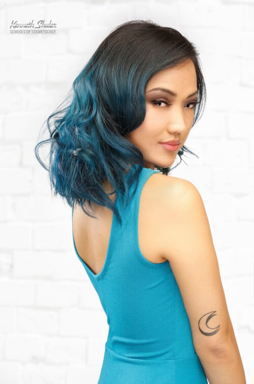 A flawless deep side part with teal blue hair color