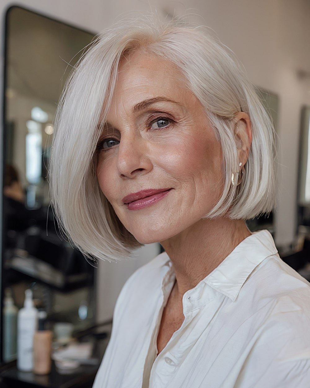 Sleek blunt bob with side part and icy platinum color for mature women