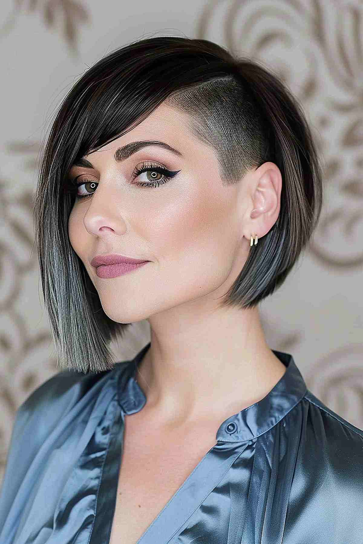 A woman with a long bob, undercut and bangs.