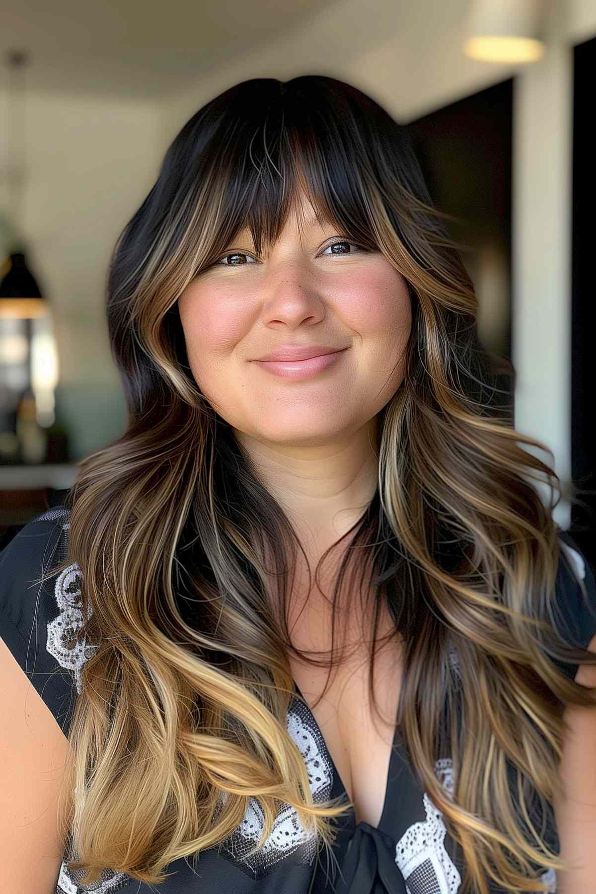 Woman with bold bangs, long layered hair, and blonde highlights