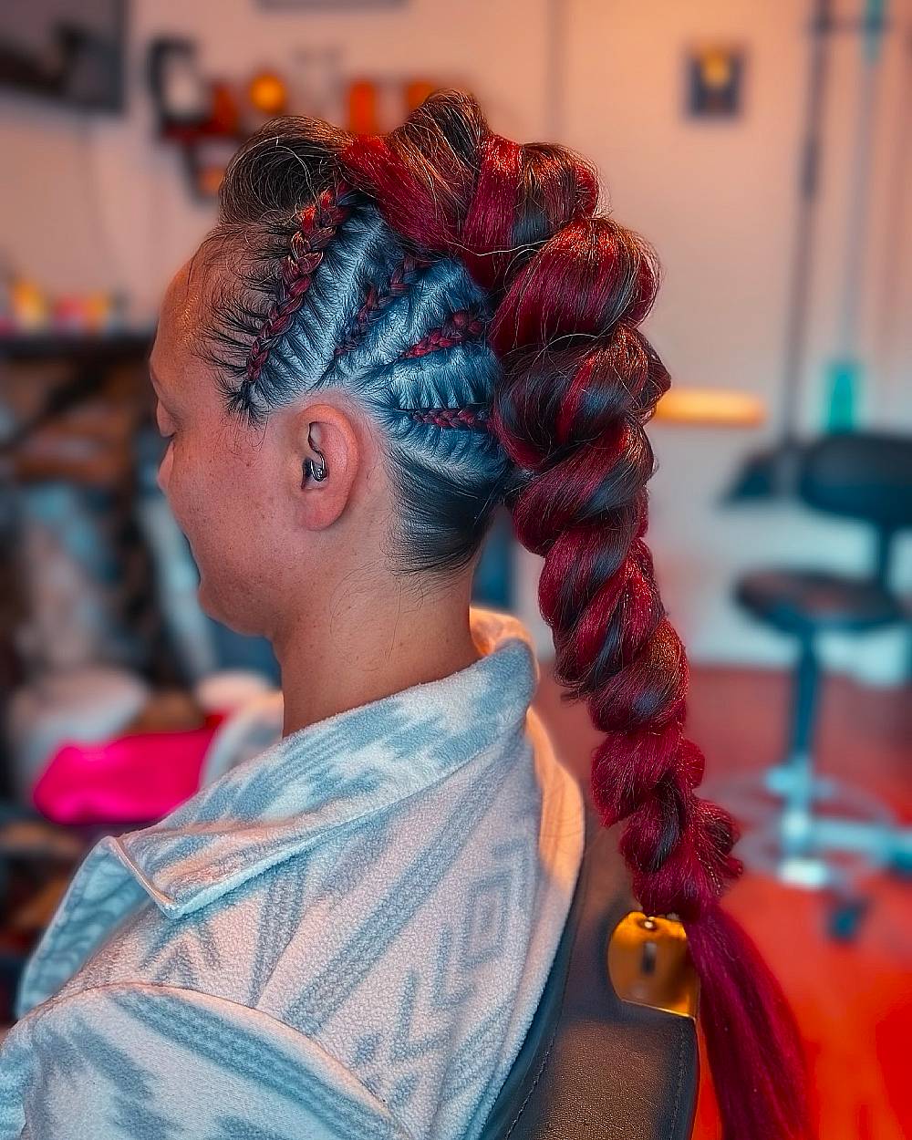 Bold red twisted mohawk braid with cornrowed sides for an edgy braided hairstyle