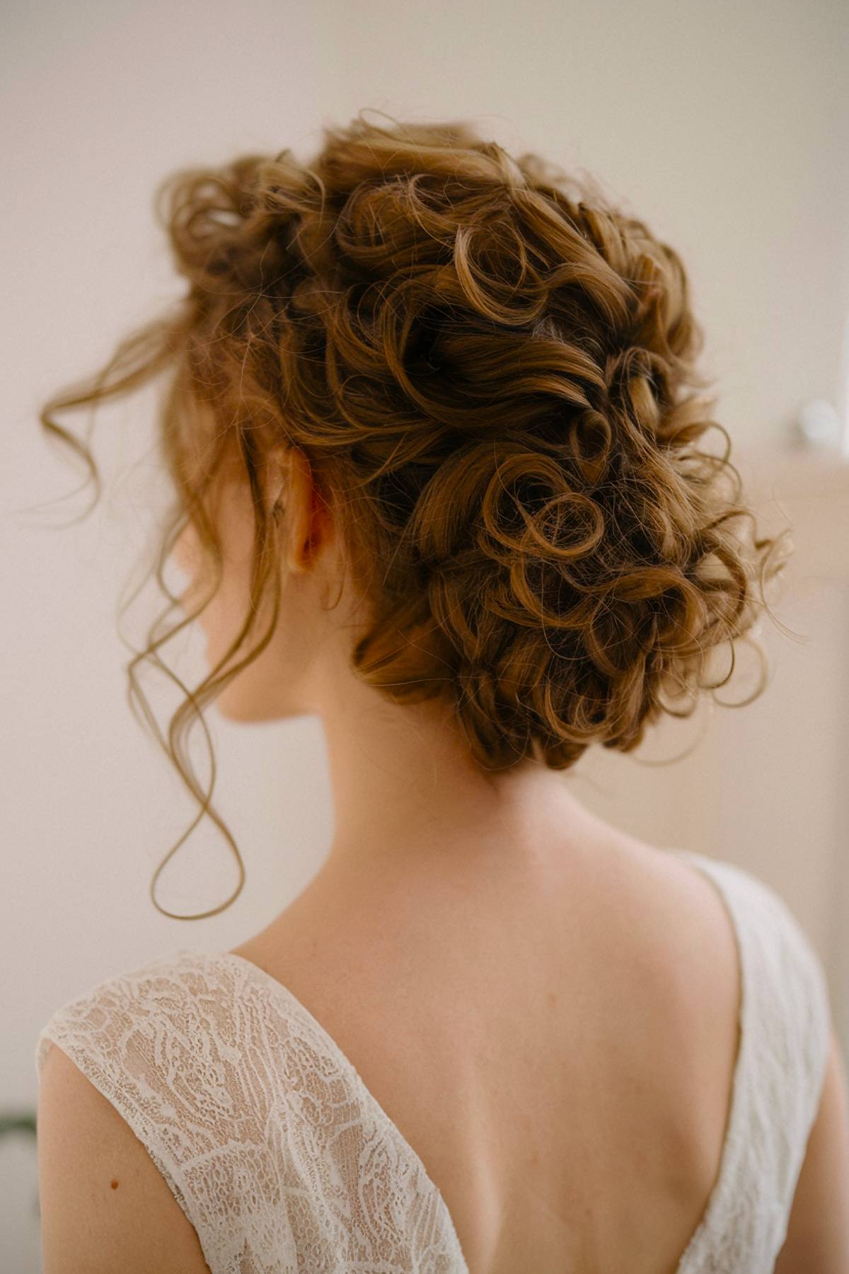 Textured curly Bouclébun hairstyle with soft, defined curls for added volume