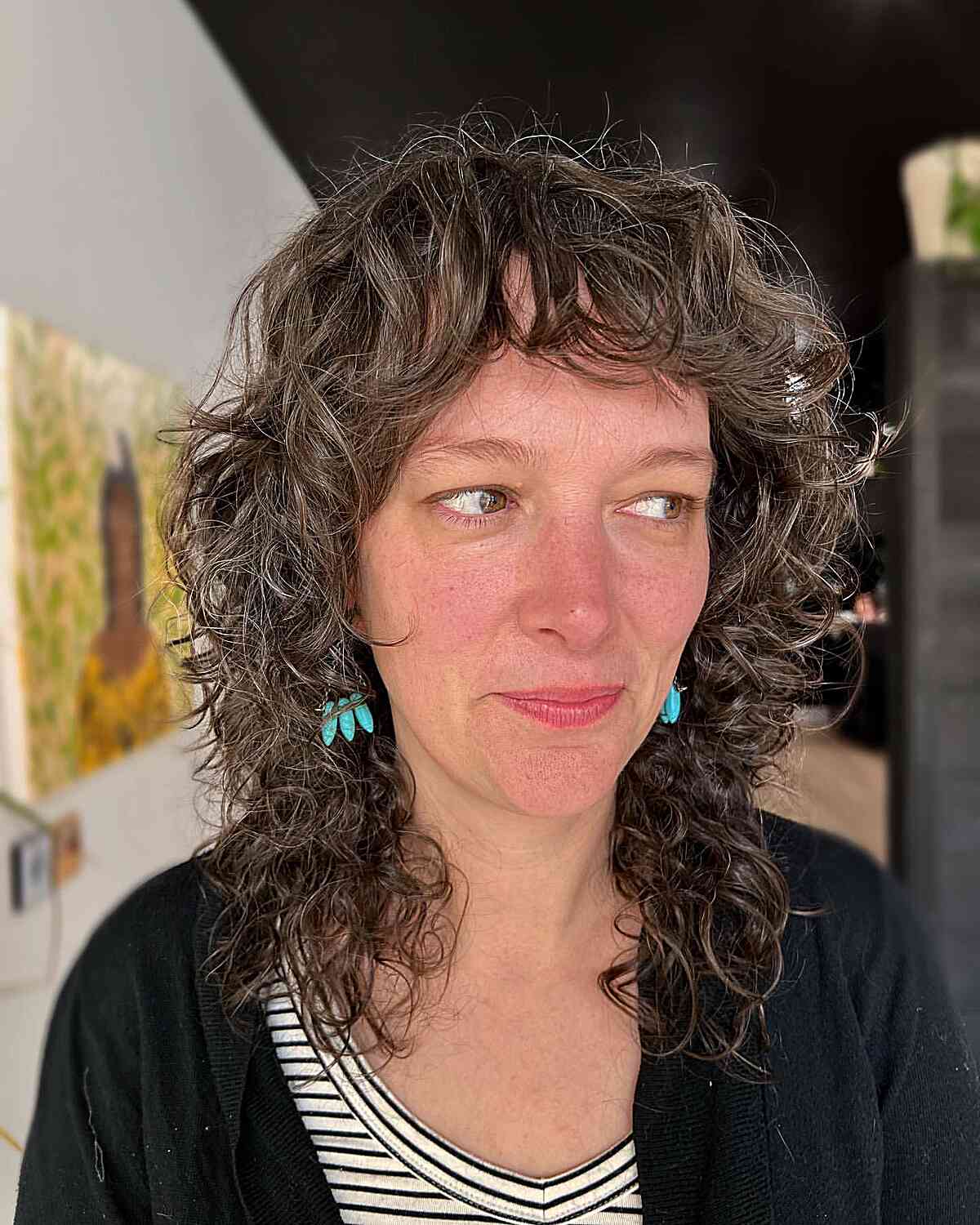 Mid-Length Brown Shag with Textured Curls and Bangs for Women Aged 40