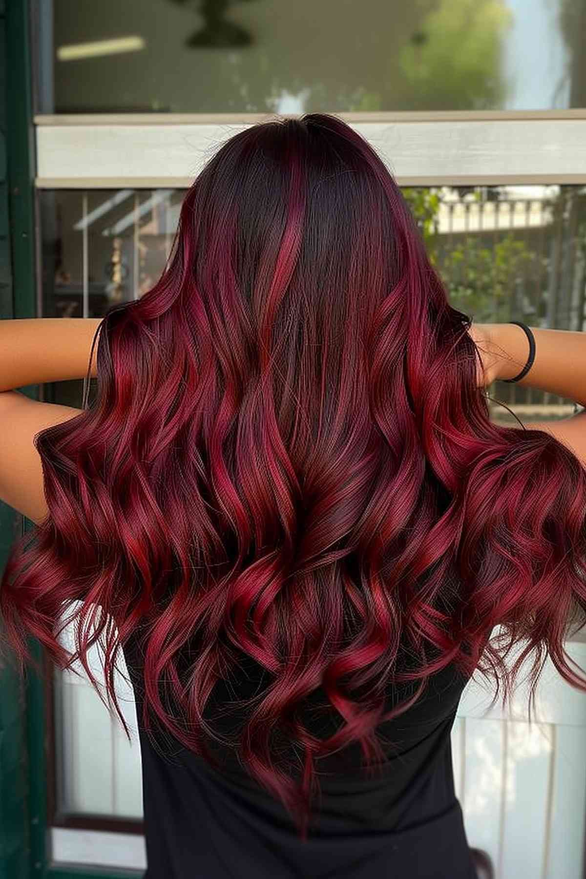 Rich cherry red hair with burgundy tones, enhancing thick, wavy hair texture.