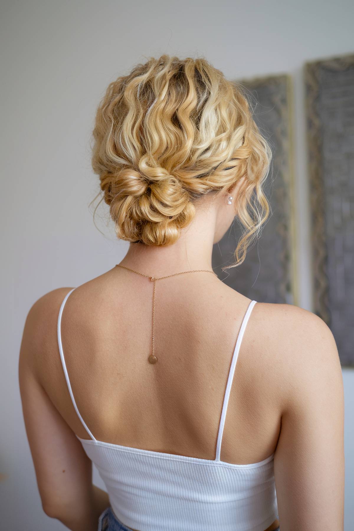 Simple low curly hair bun for a casual, everyday look with soft, natural waves