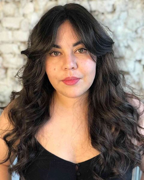 A Center Part Bangs and Long Tousled Waves to Frame Rounder Face Shapes