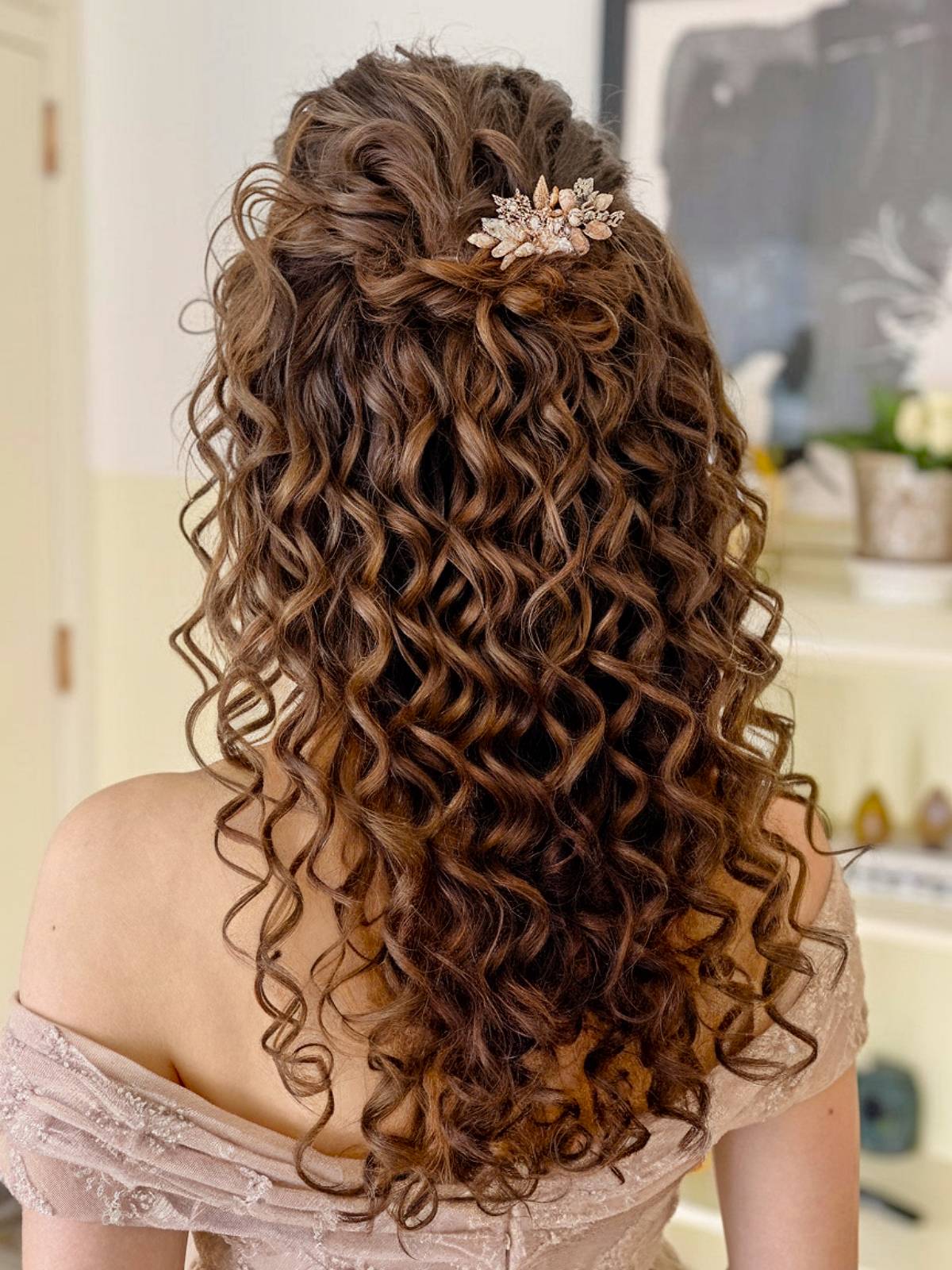 Half-up bridesmaid hairstyle with long curls and floral clip