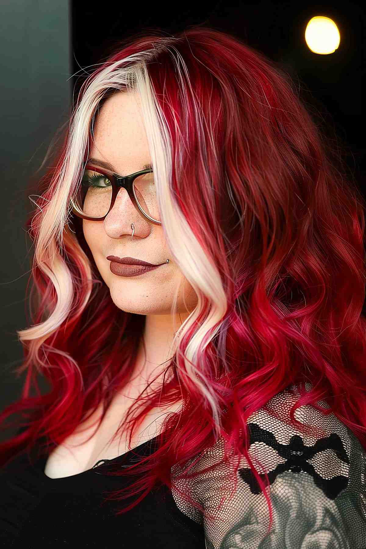 Cherry red hair with a contrasting blonde money piece, highlighting thick hair.