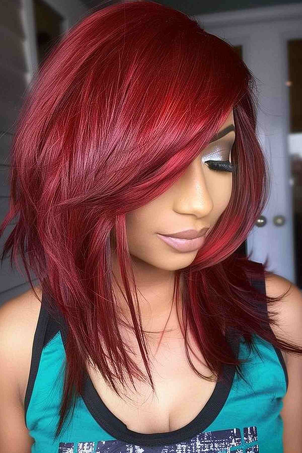 Medium-density cherry red hair with feathered bangs, framing the face.