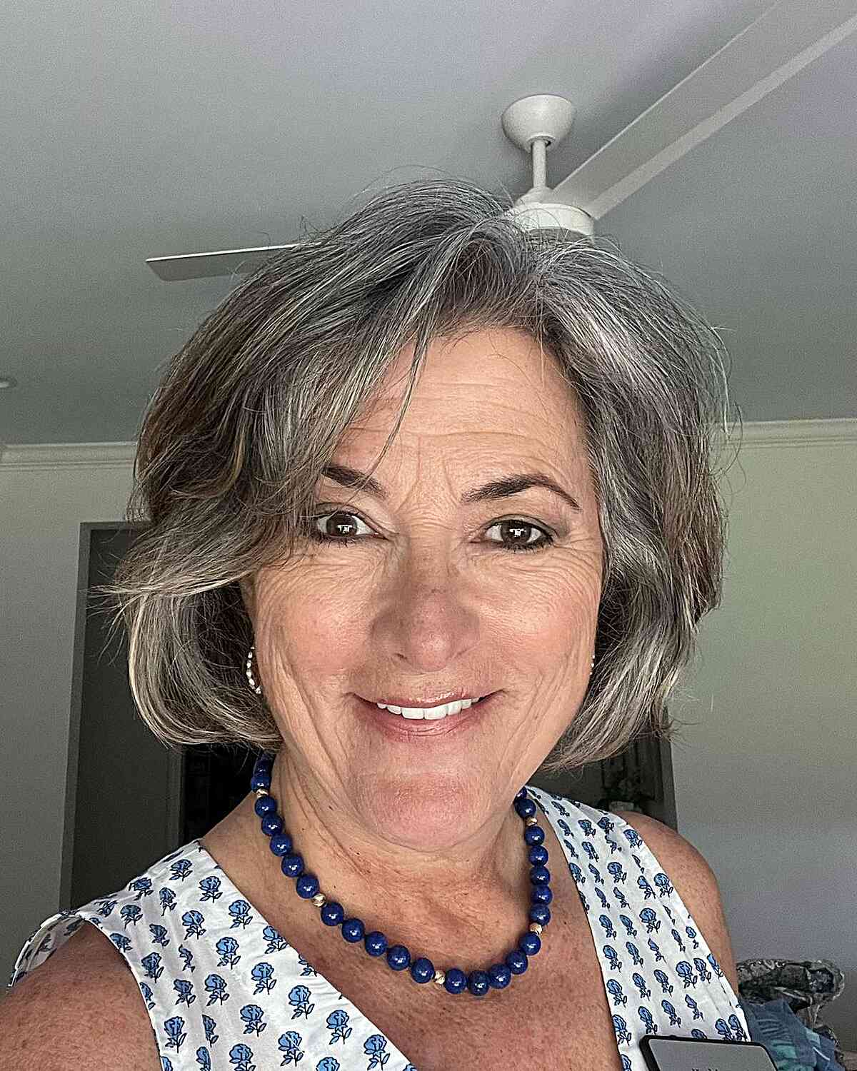 Chin-Length Gray Layered Bob with Side-Swept Bangs for 60-year-olds