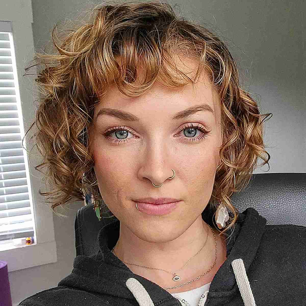 Loose curly wavy hair with a chin length side part asymmetrical cut
