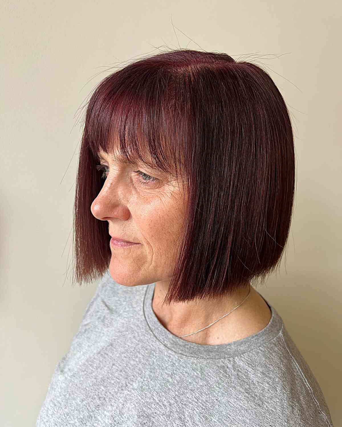 Chin-Length Sleek Bob Cut and Bangs with Maroon Red Color for Older Ladies Passed 60