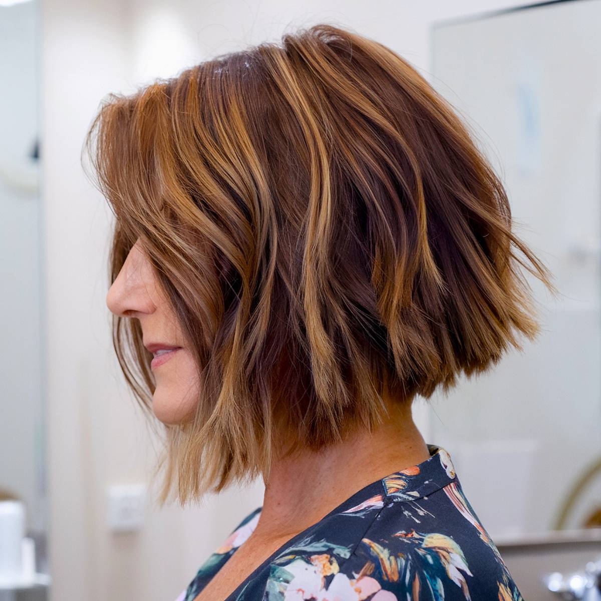 Choppy angled bob with tousled layers for a trendy and voluminous finish, perfect for mature ladies