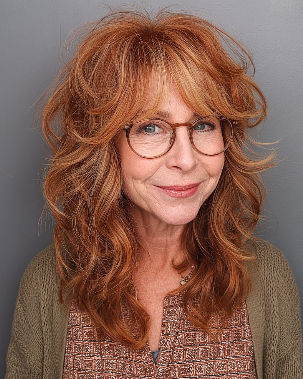 Voluminous medium red hair with choppy layers and soft curtain bangs for older women with thick hair