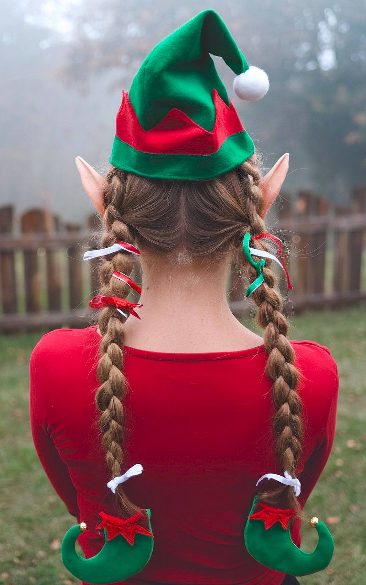 Elf-themed braids with red and green ribbons and mini elf shoe accessories for a fun Christmas hairstyle