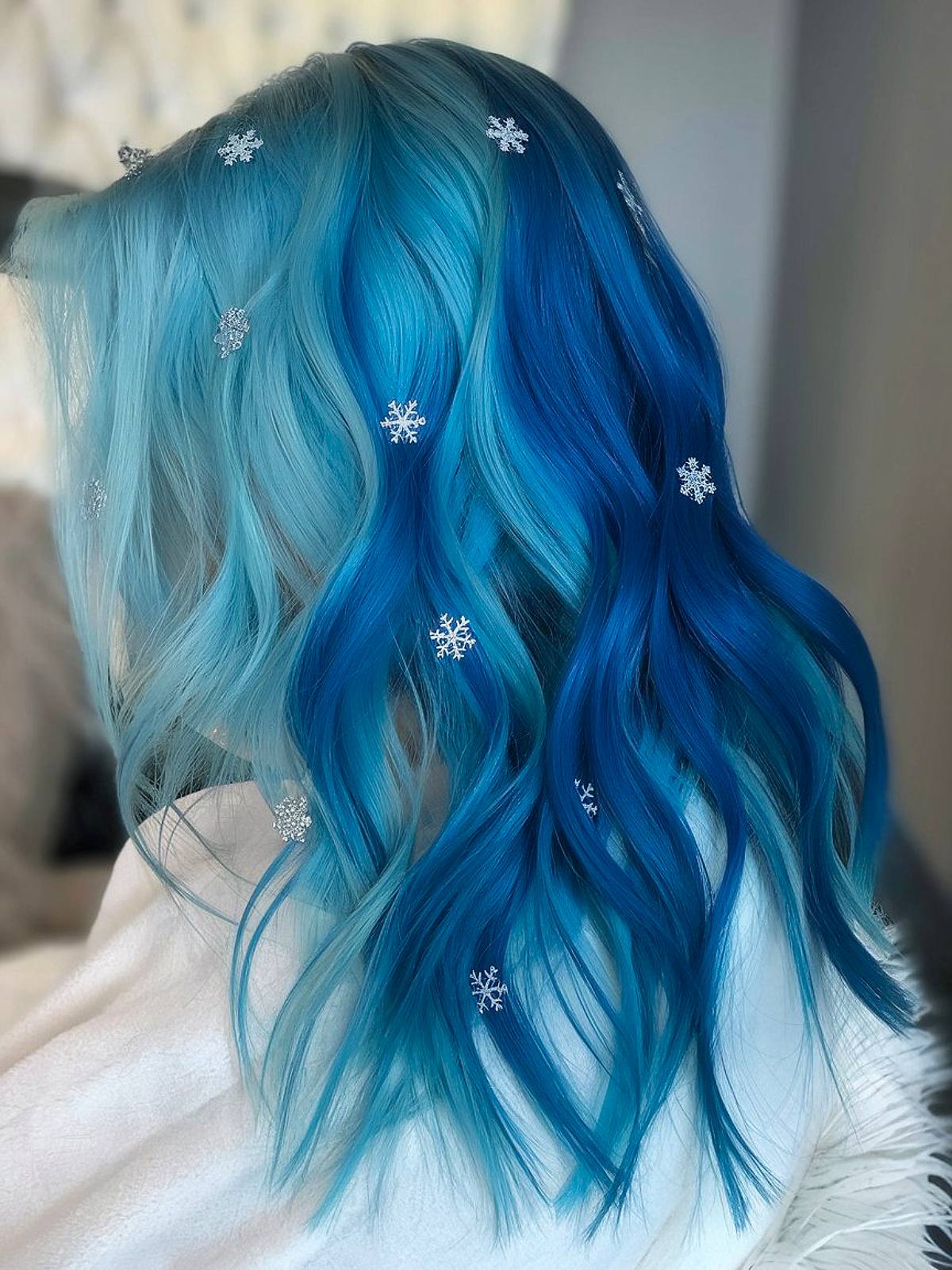 Christmas hair color idea with icy blue ombré waves and snowflake accessories