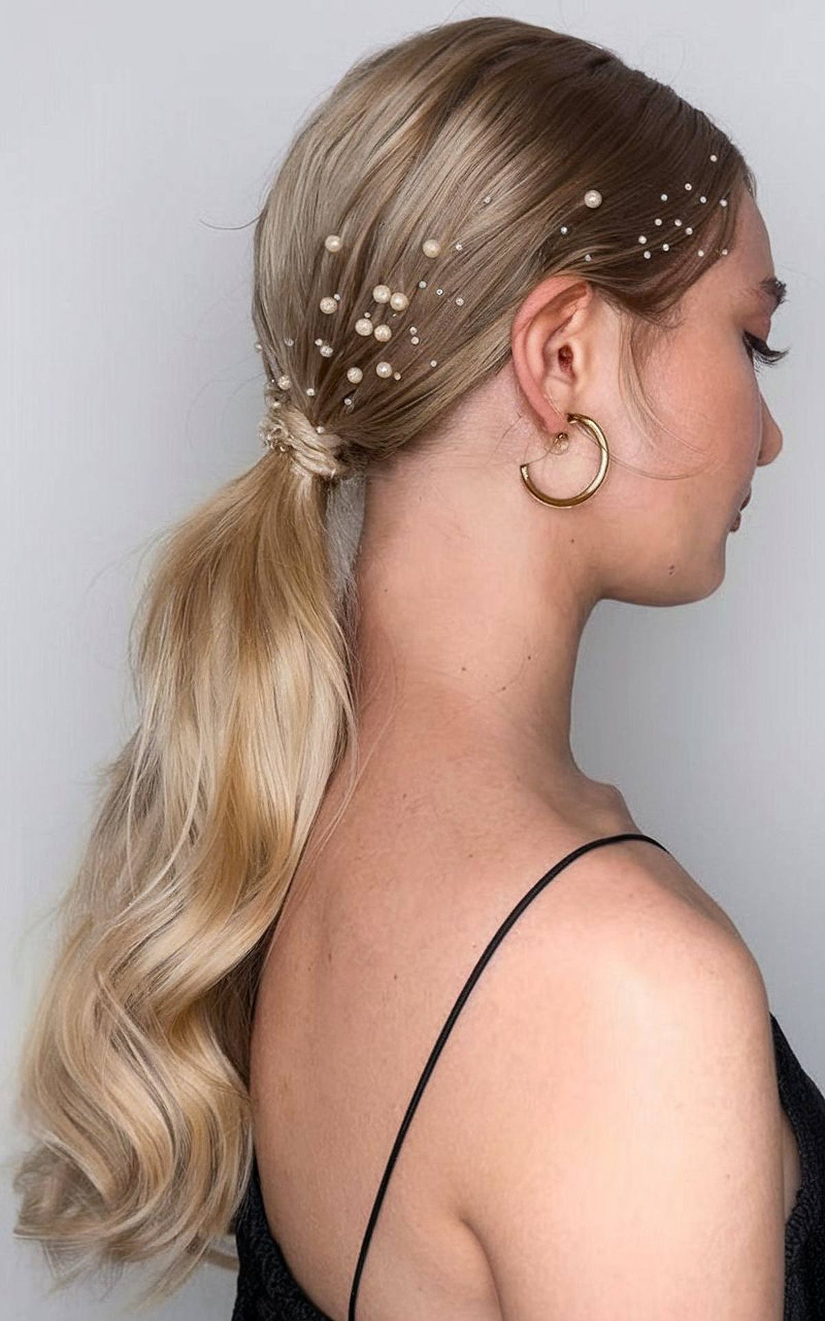 Low wrapped ponytail with pearls for a Christmas party