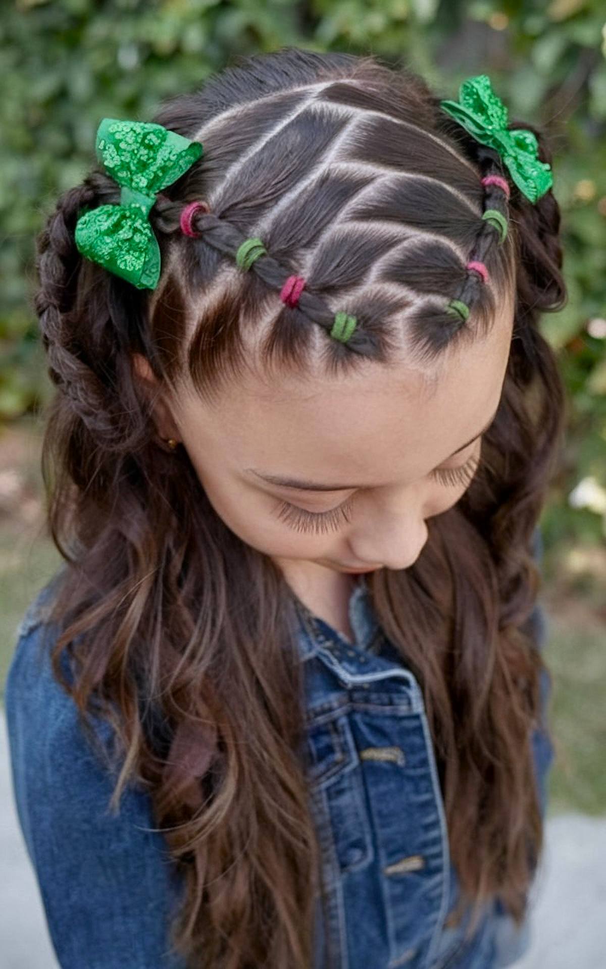 Child's criss-cross braid with red and green elastics and green bows for Christmas hair