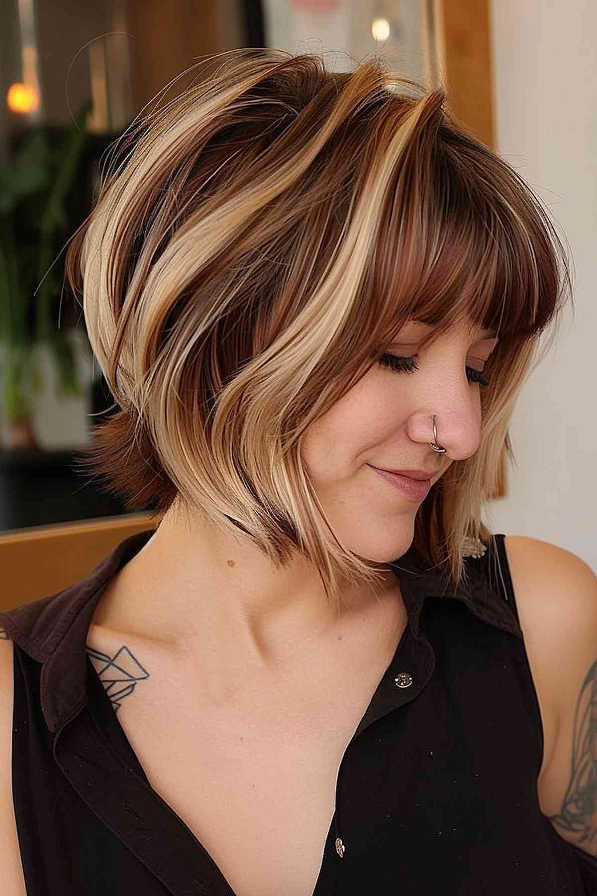 Short brown bob with chunky blonde highlights and full bangs
