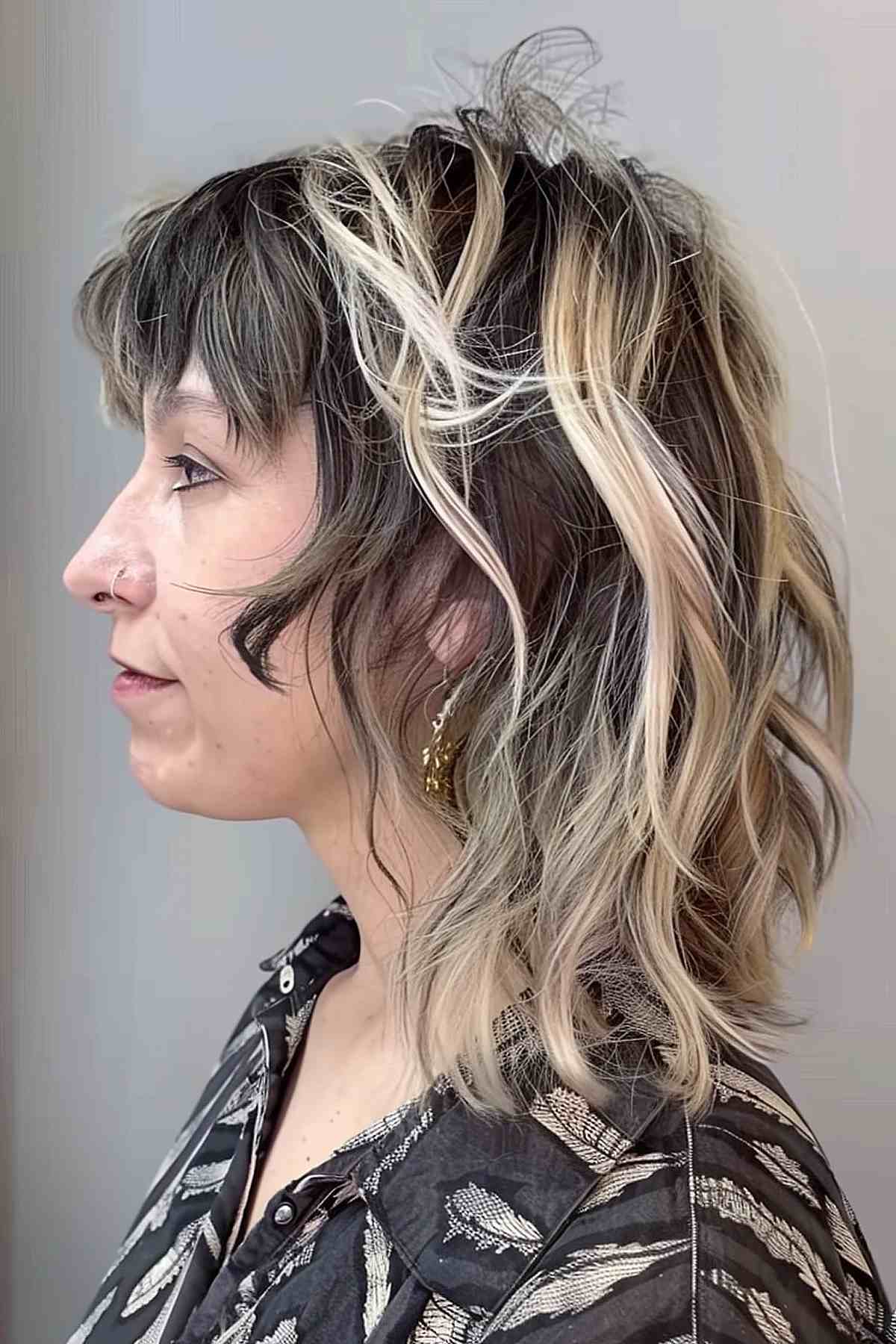 Mullet cut with dark hair and chunky blonde highlights