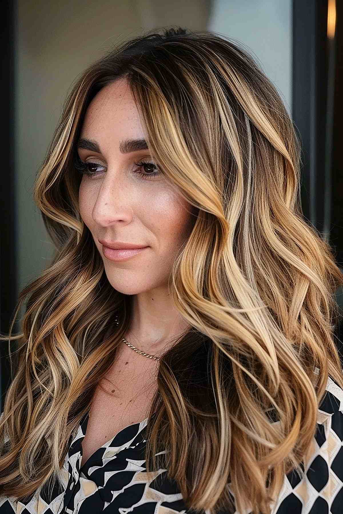 Long wavy hair with dirty blonde chunky highlights and dark roots