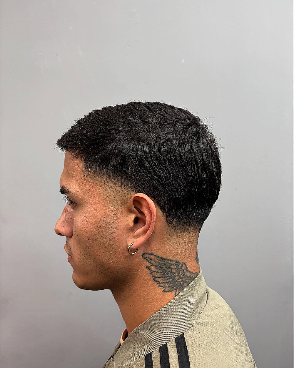 Tidy cropped haircut with low taper fade on the sides for short, textured men’s hair