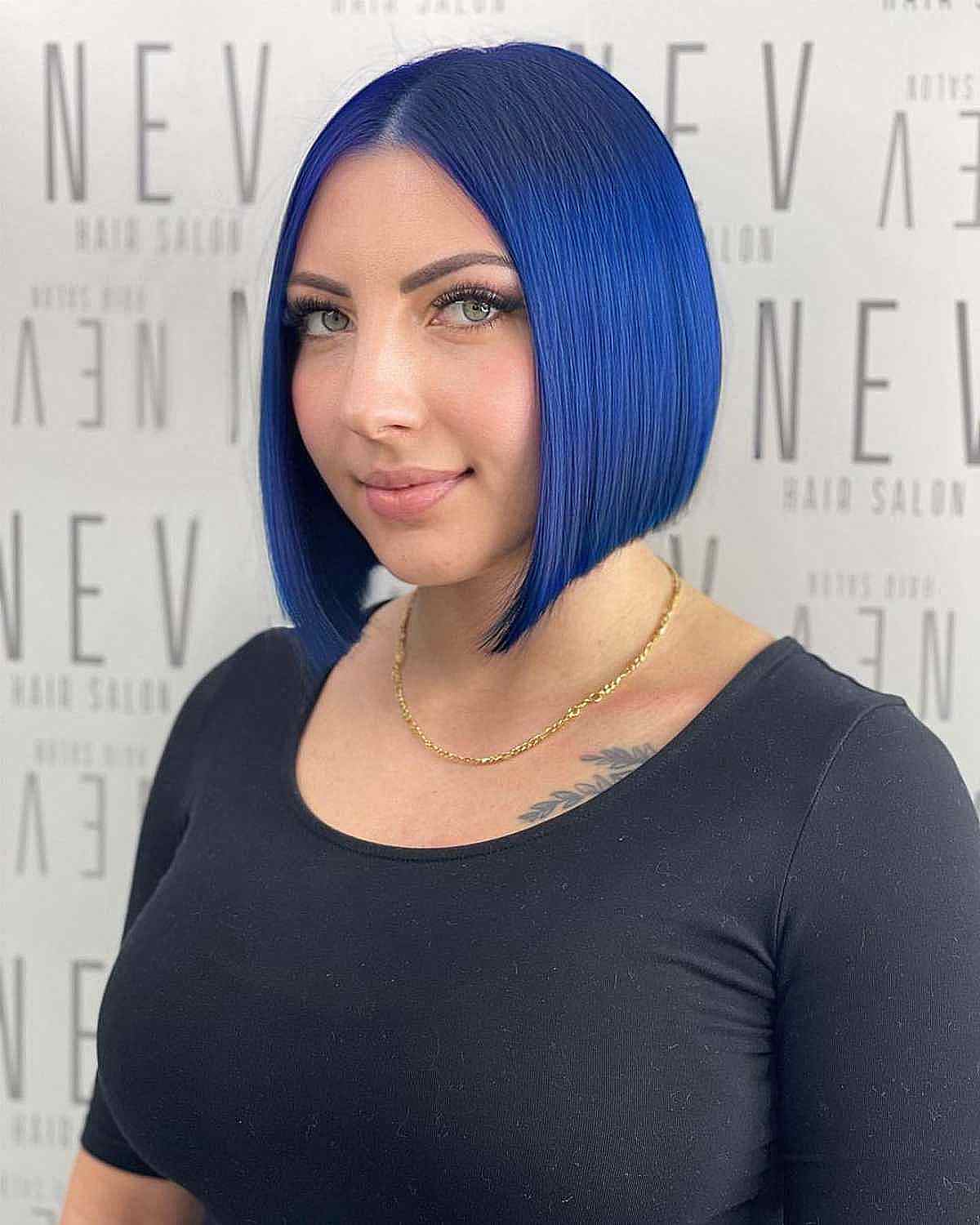 Woman with a vivid cobalt blue A-line bob haircut framing her oval face