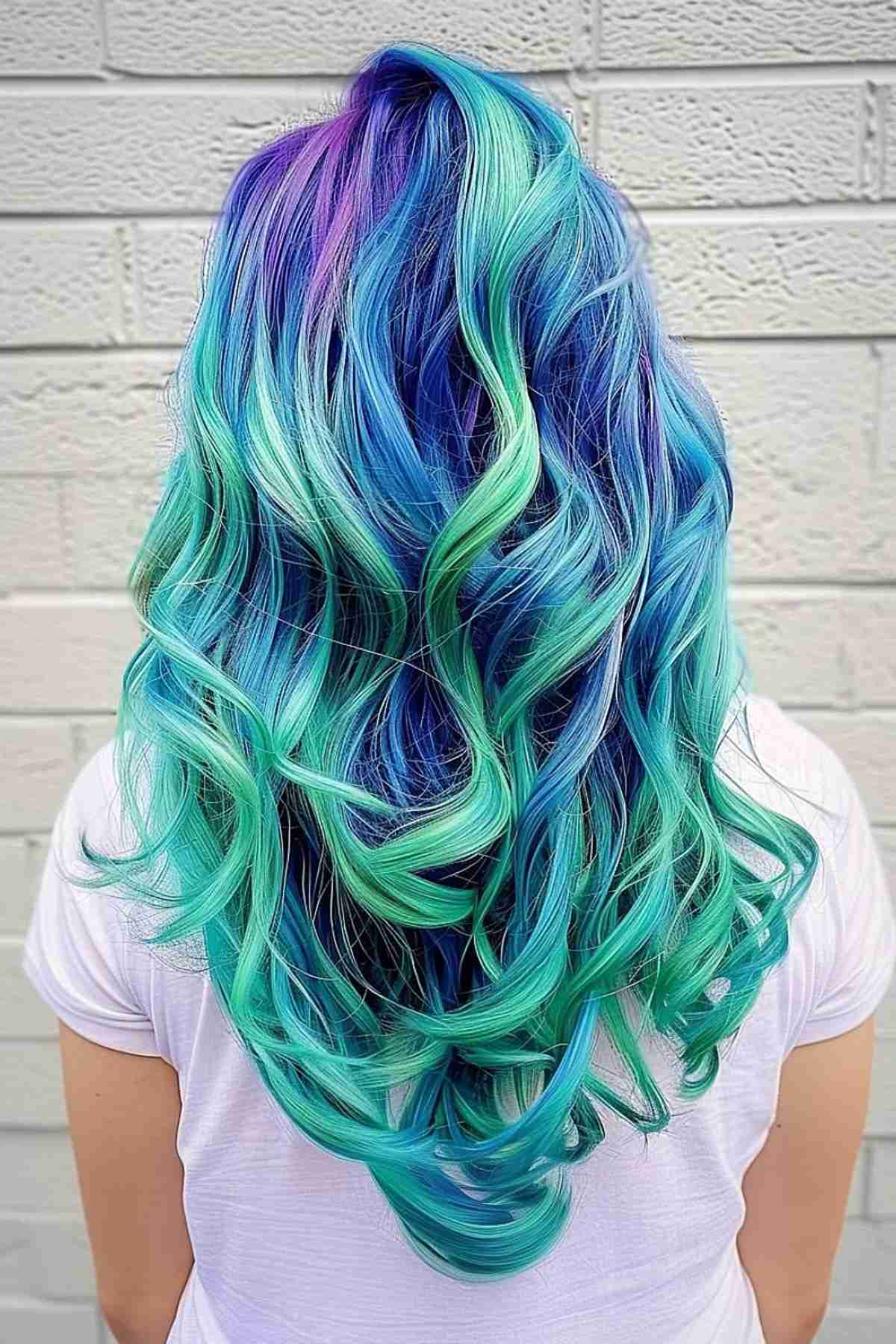 Long layered mermaid hair with a gradient from deep blue to teal and green