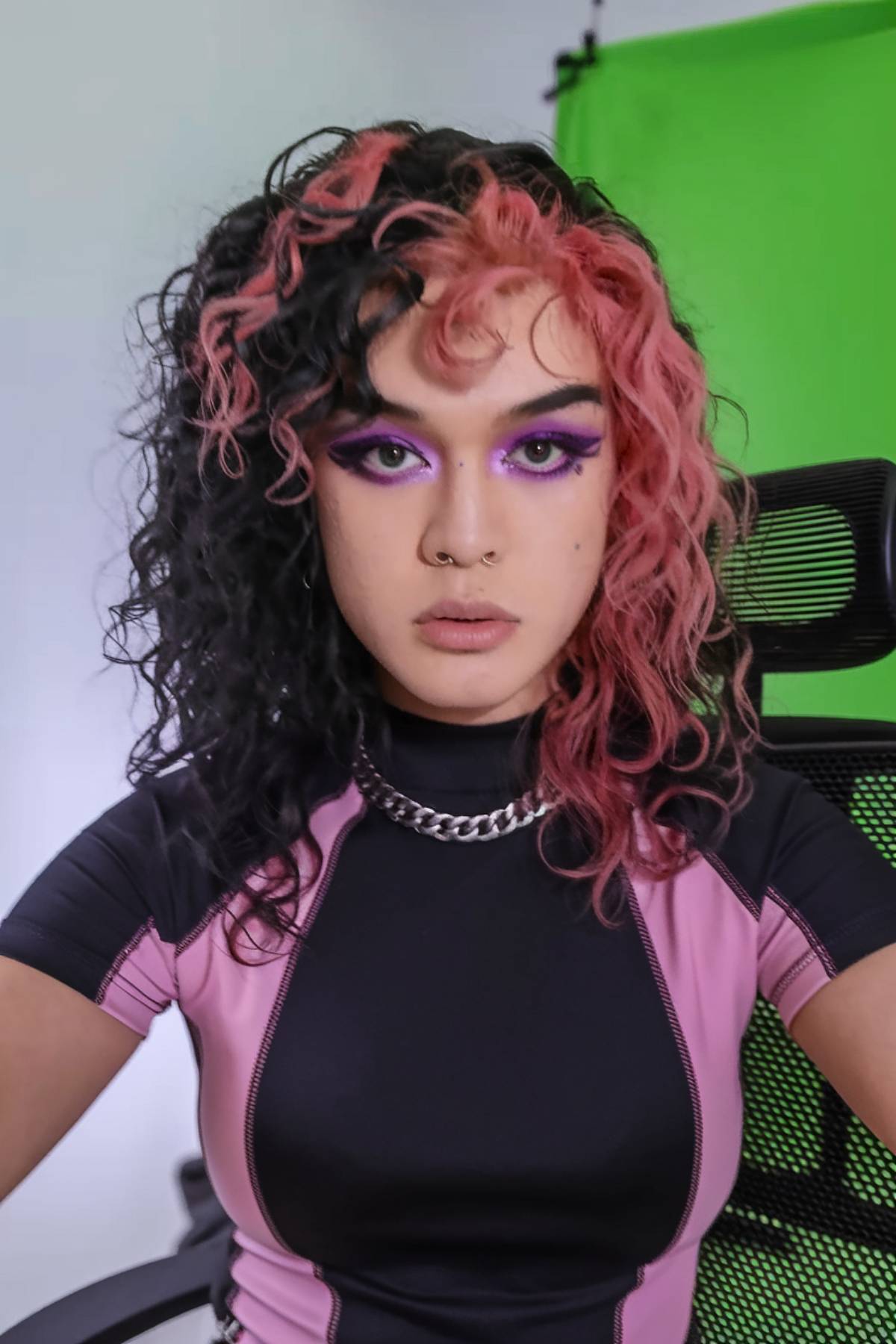 Bold 4C emo hairstyle with split black and pink curls and face-framing curly bangs